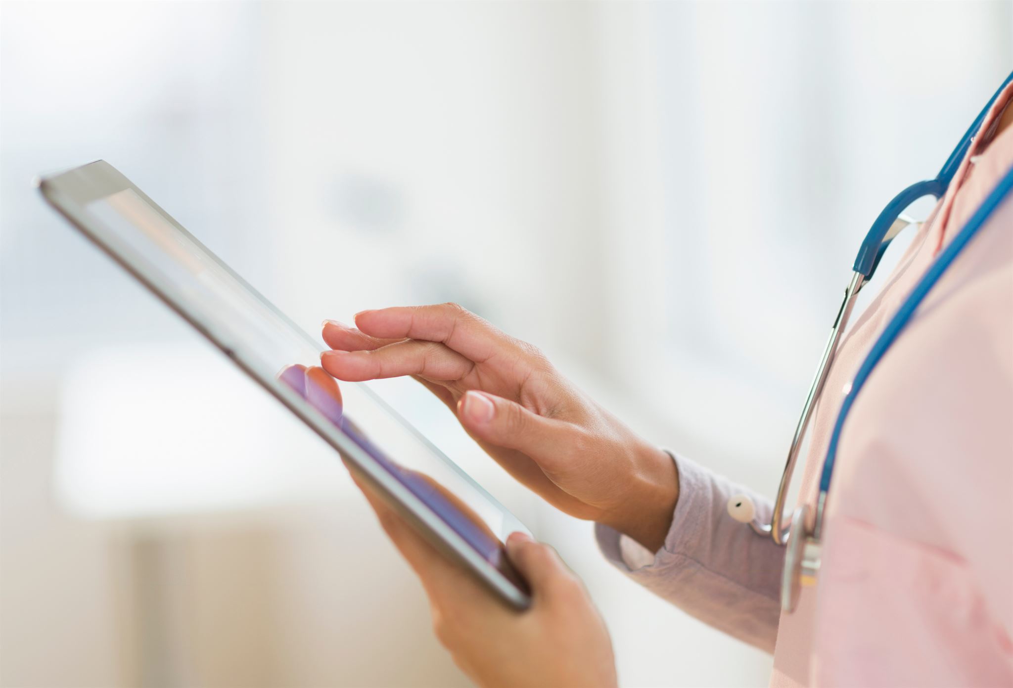 Person-with-stethoscope-using-tablet